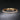 Gold-tone tennis bracelet with cubic zirconia on a dark background