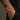 Pulsera dorada con placa ovalada grabada con LOVE YOU, en la muñeca de un hombre