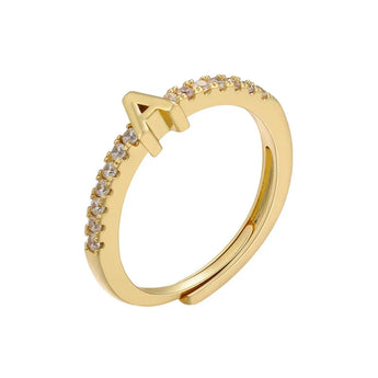 Anillo abierto en tono dorado con inicial A y banda de circonitas cúbicas sobre fondo blanco