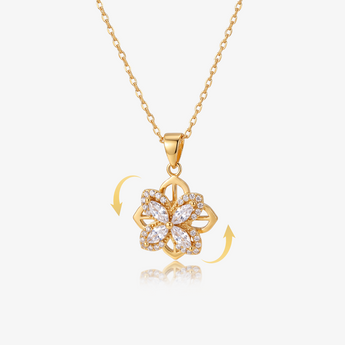Collar con dije giratorio de trébol de cuatro hojas en tono dorado con piedras transparentes, flechas que muestran el giro