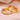 Dos anillos de pareja de acero inoxidable dorado grabados con love you y forever sobre satén rosa
