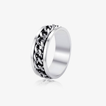 Anillo giratorio de cadena cubana en tono plateado sobre fondo gris claro