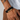 Man wearing a black braided leather bracelet with a gold-tone plate engraved Love You