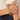 Gold paperclip chain bracelet with letter A charm worn on a wrist