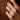 Hand wearing a gold-tone custom engraved open wrap ring against a brown knit sweater