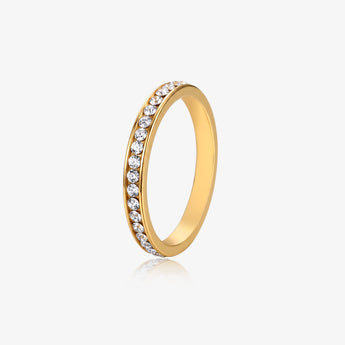 Gold-tone eternity band ring with a row of cubic zirconia stones on a light background