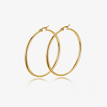 Gold-tone large round stainless steel hoop earrings pair on light grey background