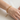 Pulsera de cadena en capas con cuentas en tono dorado puesta en la muñeca