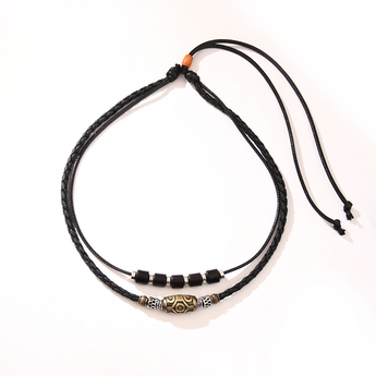 Black two-strand cord necklace with bead pendant and adjustable knot on a cream background