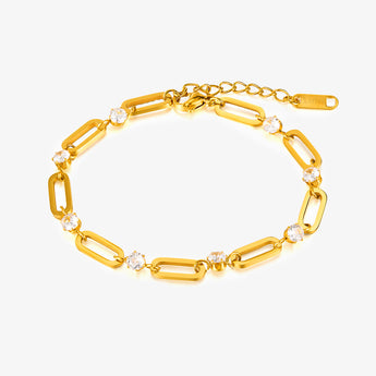 Pulsera de eslabones dorada con circonitas cúbicas y cadena de extensión sobre fondo blanco