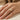 hand wearing a gold-tone open wrap ring with white marbled inlay on a finger