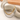 Gold-tone and silver-tone Cuban chain necklaces draped over a beige sculpture