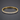 Gold-tone tennis bracelet with cubic zirconia and a fold-over clasp on a dark background