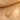 Gold-tone infinity necklace close-up on cream fabric