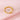 Anillo abierto con inicial en tono dorado con diámetro interior de 1.9 cm indicado, sobre fondo rosa