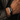 Hombre con una pulsera de cuero trenzado negro y placa plateada grabada con DON'T LET THE HARD DAYS WIN
