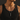 Man in a black tank top wearing a silver square prism necklace, close-up of the pendant