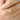 Hand wearing the gold-tone four-leaf clover ring with clear marquise stones