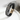 Black multilayer bracelet with infinity charm standing on white plate