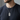 man in a dark t-shirt wearing a silver-tone chain necklace with a razor blade shaped pendant