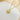 gold-tone sunflower zirconia pendant resting on a white tray with cream fabric